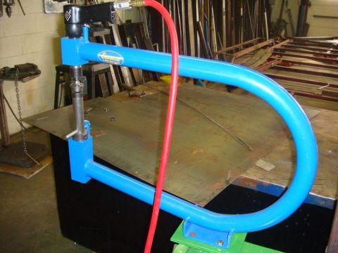 1996 Ford Bronco - A blue metal shaping tool, likely a bead roller or English wheel, is set up on a workbench with sheet metal.