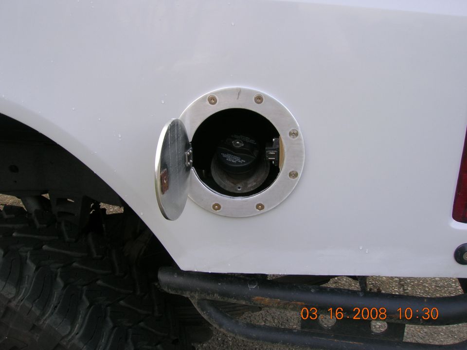 Billet aluminum fuel door open on white truck body showing filler neck