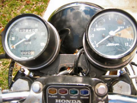1985 Ford Crown Victoria LTD - Close-up of a motorcycle's instrument cluster, a speedometer, tachometer, and indicator lights for flash, oil, neutral, and beam. The HONDA…