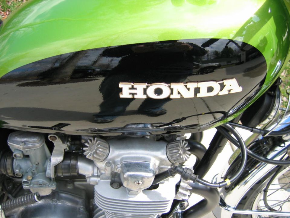 Close-up of a Honda motorcycle's engine and green/black fuel tank with the 'HONDA' emblem visible
