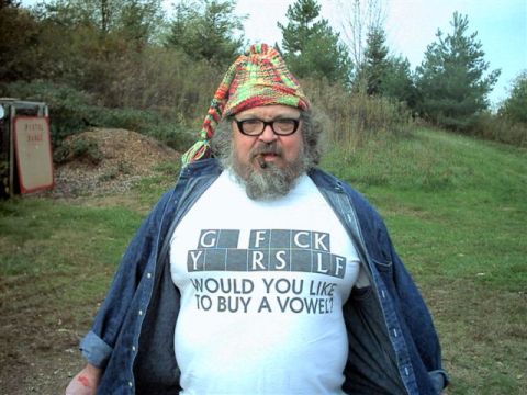1992 Ford Mustang - A man stands outdoors wearing a t-shirt with a controversial message and a knitted hat.