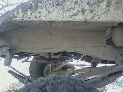 1992 Ford F-350 - Mud-covered undercarriage of a truck, with visible suspension components and frame.