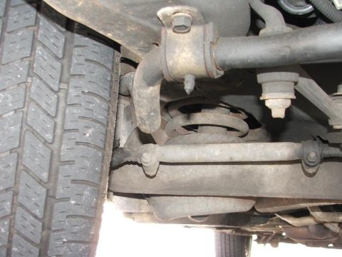 1985 Ford Crown Victoria LTD - Close-up view of the suspension system and tire of a 1985 Ford Crown Victoria LTD.