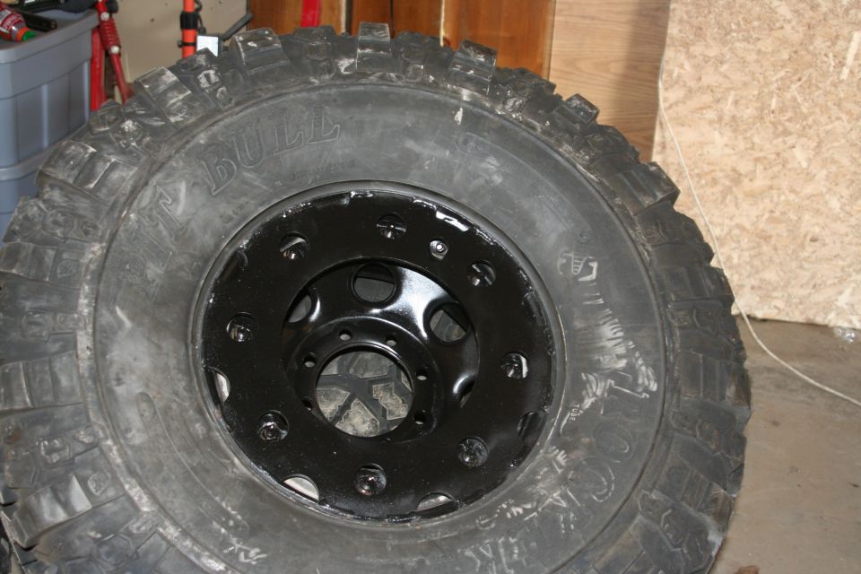 Tire and black rim with lug nuts