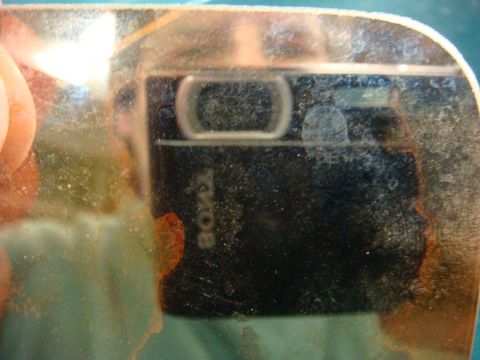 1996 Ford Bronco - A close-up view of a camera lens, showing the brand name and significant dust and smudges.
