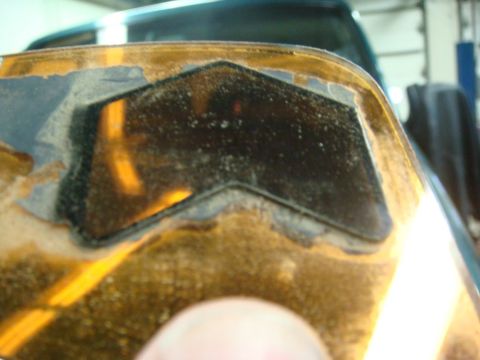 1996 Ford Bronco - Close-up of a vehicle's signal mirror housing, showing wear and a dark inset area.