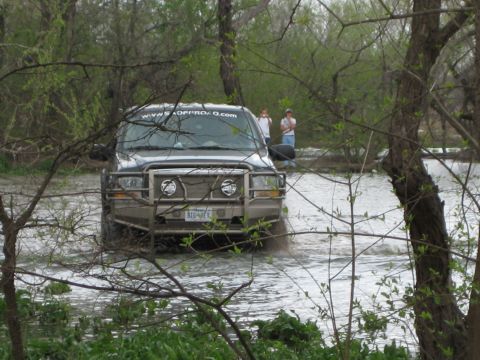 1996 Ford Bronco - Ford F-250 Super Duty navigates through a flooded area, with two onlookers present.