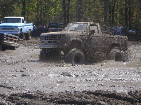 1989 Ford Bronco - Pickup truck engulfed in mud during an off-road event.