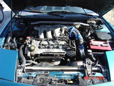 1993 Ford Probe - The engine bay of a teal vehicle, a V6 engine and custom blue intake piping.