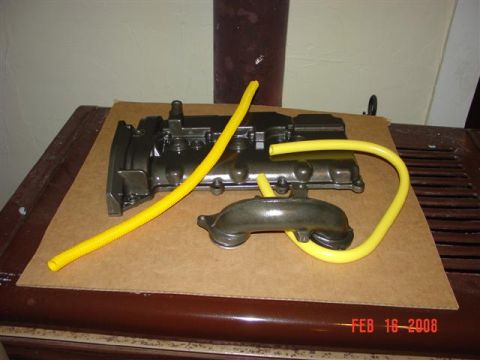 1993 Ford Probe - Engine parts with yellow hoses are laid out on cardboard.