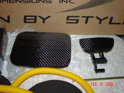 1993 Ford Probe - Two carbon fiber automotive parts, a gas cap and a door handle assembly, are displayed with a yellow hose and text indicating "DIMENSIONS I…