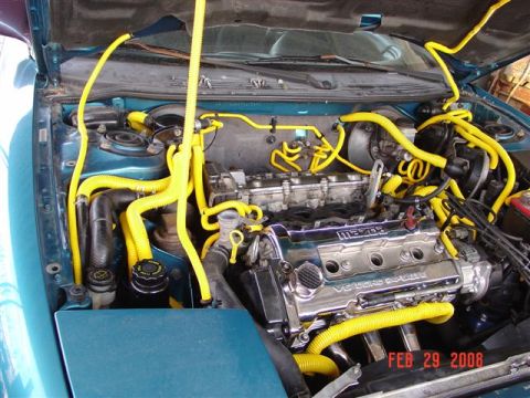 1993 Ford Probe - The engine bay features a Mazda V6 engine with extensive yellow hose and tubing modifications.