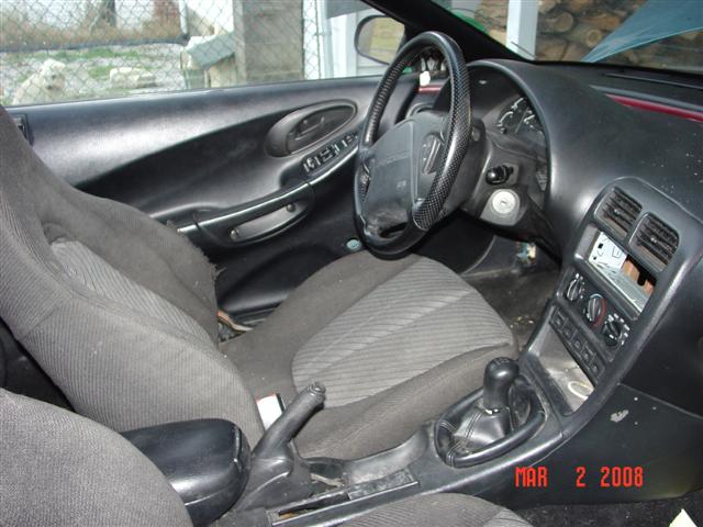 Black coupe interior with manual shifter, cloth bucket seats and carbon-look steering wheel