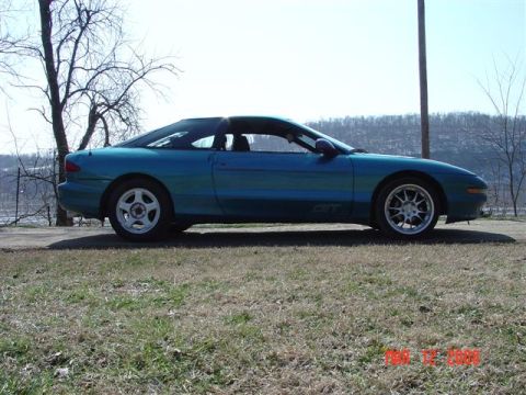 1993 Ford Probe - A teal 1993 Ford Probe GT is shown from the side, parked outdoors on a sunny day.