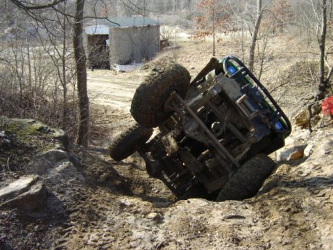1992 Ford Bronco - This off-road vehicle has tipped onto its side while navigating a challenging, muddy terrain.