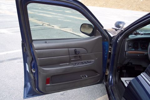2001 Ford Crown Victoria - Interior view of a 2001 Ford Crown Victoria police car, showing the driver's side door panel and dashboard.