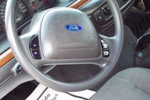 2001 Ford Crown Victoria - The interior of a 2001 Ford Crown Victoria, the steering wheel with the Ford emblem and visible dashboard instrumentation.