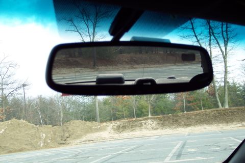 2001 Ford Crown Victoria - View from inside a vehicle, looking through the rearview mirror at an outdoor scene.