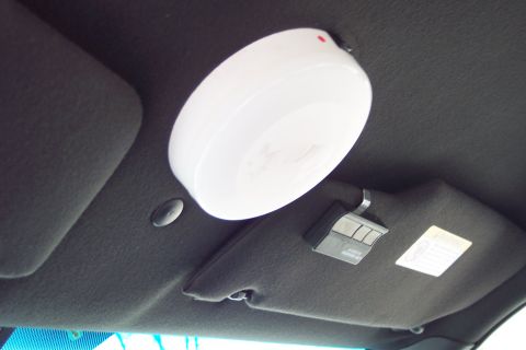 2001 Ford Crown Victoria - The interior of a car shows a white dome light and a garage door opener mounted on the sun visor.