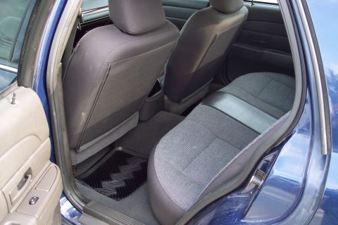 2001 Ford Crown Victoria - Interior view of the back seat area of a blue sedan, with a focus on the seats and floor mat.
