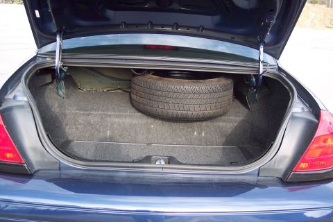 2001 Ford Crown Victoria - The trunk of a dark blue 2001 Ford Crown Victoria, showing the spare tire and interior lining.