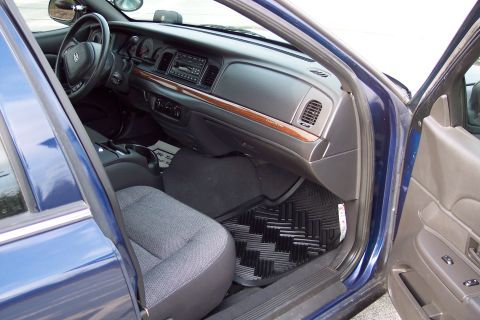 2001 Ford Crown Victoria - The interior of a blue 2001 Ford Crown Victoria, fabric seats and a wood-grain trim on the dashboard.