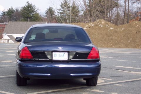 2001 Ford Crown Victoria - Rear view of a dark blue 2001 Ford Crown Victoria, showing its taillights and license plate.