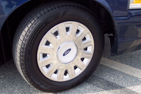 2001 Ford Crown Victoria - The front wheel and tire of a 2001 Ford Crown Victoria are shown in this close-up shot.