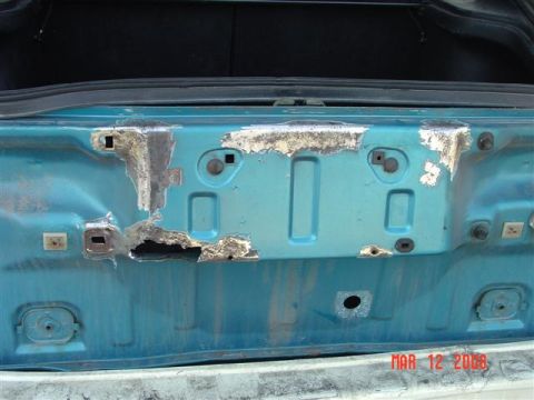 1993 Ford Probe - Interior of a car trunk lid showing significant rust and damage to the metal.