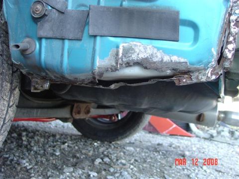 1993 Ford Probe - Rusted car body panel and fuel tank are visible in this close-up shot.