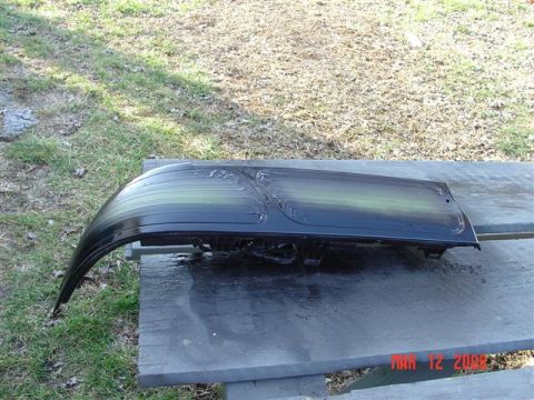 1993 Ford Probe - A car taillight assembly is shown resting on a weathered wooden surface, with grass and dirt in the background.
