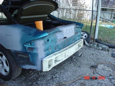 1993 Ford Probe - The rear of a 1993 Ford Probe is shown with its bumper removed, revealing exposed bodywork and primer.