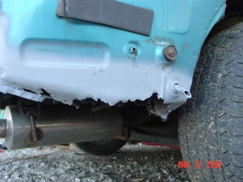 1993 Ford Probe - Rust damage is evident on the rear quarter panel of this teal vehicle, with the exhaust system also visible.