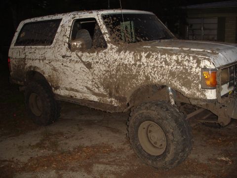 1989 Ford Bronco - This heavily muddied 1987 Ford Bronco is shown from a 3/4 front angle.