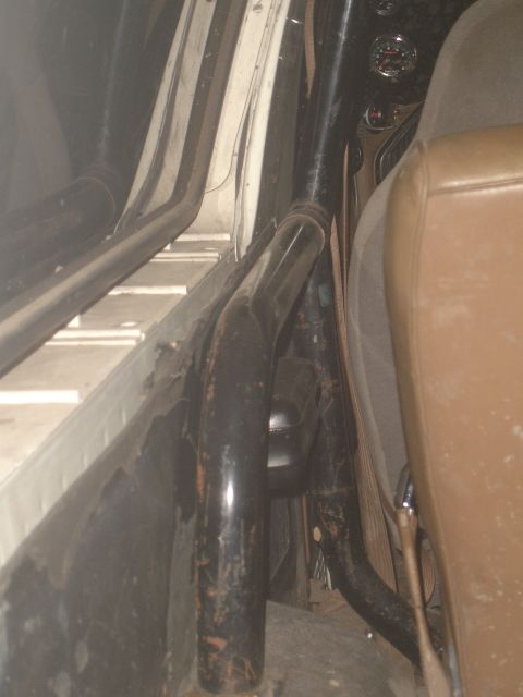 1989 Ford Bronco - Close-up of a vehicle's interior, showing a roll cage and seat.