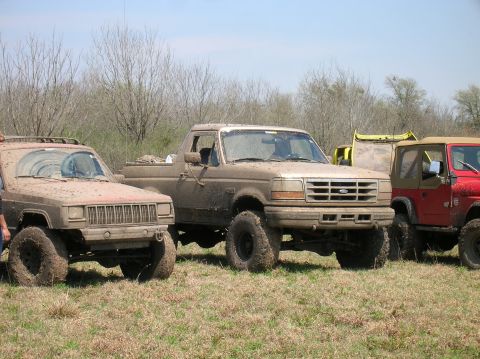 1996 Ford Bronco - Three off-road vehicles covered in mud at Marlin City Lake, Marlin TX.