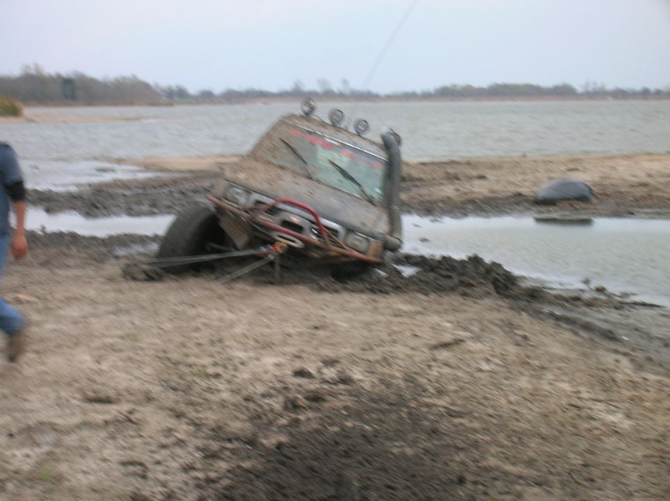 1996 Ford Bronco stuck deep in mud with snorkel and winch, near a body of water
