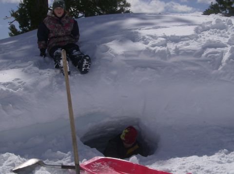 1986 Ford Bronco - Two children are enjoying a winter day, playing in a snow fort they dug out.