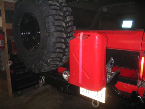 1989 Ford Bronco - Rear view of a 1989 Ford Bronco showing a spare tire and a red jerry can. The license plate is visible.