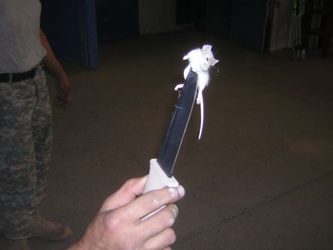 1995 Ford Bronco - A white mouse sits atop a knife blade, held by a person wearing camouflage uniform.