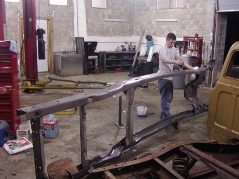 1991 Ford Bronco - A vehicle frame is being worked on in a garage setting.