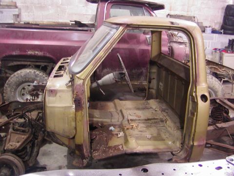 1991 Ford Bronco - This is a rusted truck cab and frame, with another truck visible in the background.