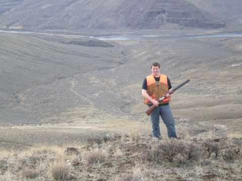 1993 Ford Bronco - A hunter stands on a hill with a shotgun, overlooking a wide, dry landscape with a river in the distance.