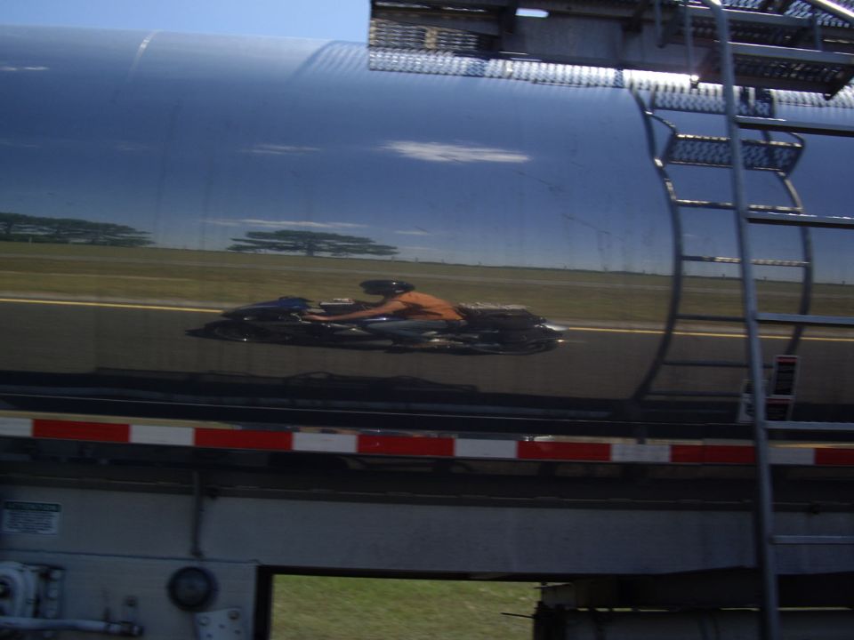 Reflection of motorcycle rider on tanker truck