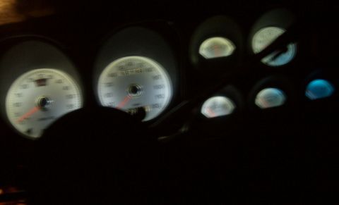 1976 Ford Ranchero - Illuminated dashboard gauges with white faces and red needles are visible in the dark interior of a vehicle.