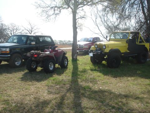1989 Ford Bronco II - Several off-road vehicles and an ATV are parked together outdoors on a grassy area.