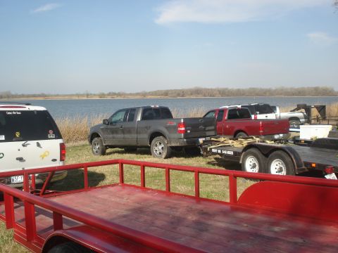 1989 Ford Bronco II - A gray 2004 Ford F-150 pickup truck is parked next to a lake, towing a trailer.