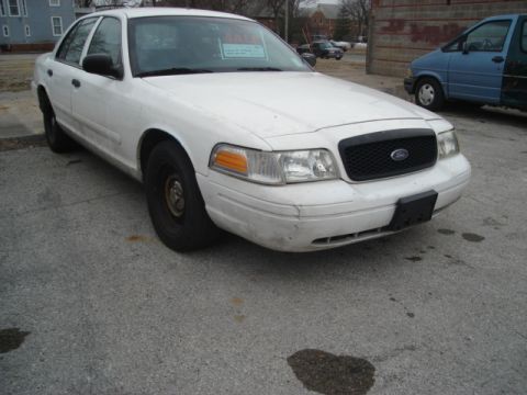 2000 Ford Crown Victoria - This white Ford sedan, possibly a 2000 Crown Victoria, is parked outdoors with a 'For Sale' sign visible.
