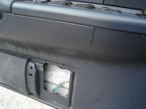 2000 Ford Crown Victoria - Interior door panel shows a crack and exposed wiring, indicating wear or damage.