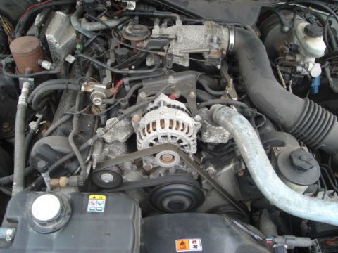 2000 Ford Crown Victoria - Close-up view of a vehicle's engine compartment, showing various mechanical components and wiring.